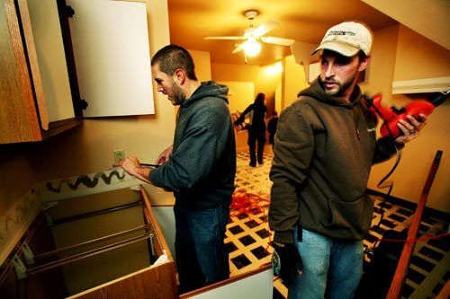 Jeromy Emerling and Jake Neufeld help renovate the new home of Kyle and Phyllis Porrett. The couple decided to move out of the communal abode after they were told they could adopt their foster children.