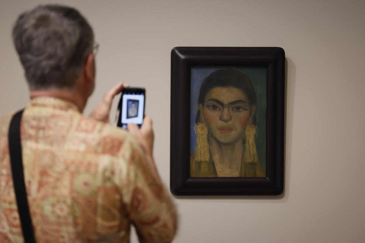 A person views LACMA's sole Diego Rivera portrait of Frida Kahlo.