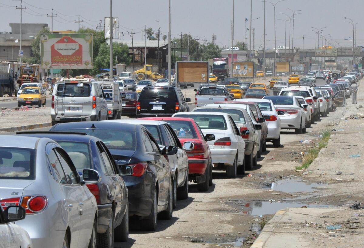 Iraqi motorists wait in line to get fuel for their vehicles Wednesday in Kirkuk following an assault on Iraq's main Baiji oil refinery.
