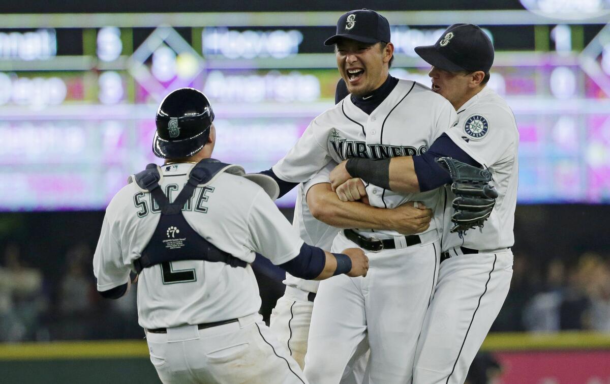 Mariners starting pitcher Hisashi Iwakuma, second from right, celebrates with catcher Jesus Sucre (2) and first baseman Logan Morrison, right, after Iwakuma threw a no-hitter against the Orioles in August.