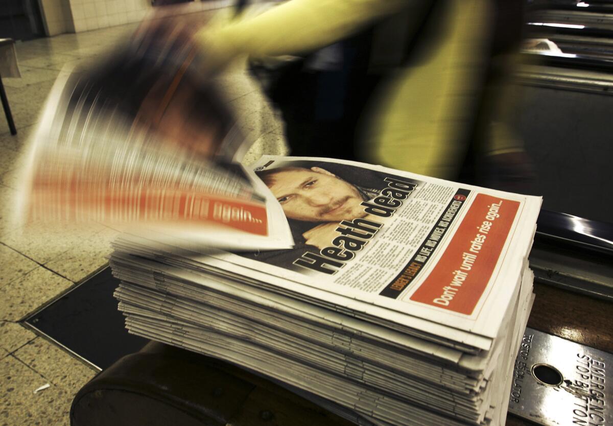 Evening commuters reach for copies of the afternoon MX newspaper reporting the news of the death of actor Heath Ledger, in Sydney, Australia, Wednesday, Jan. 23, 2008. (John Pryke / AP)