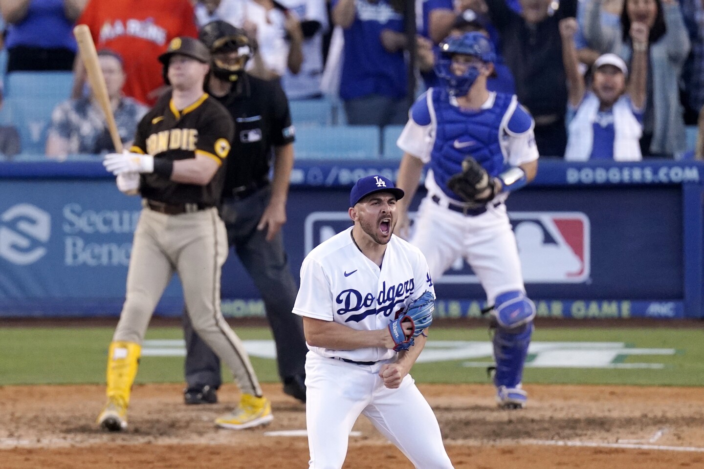 Los Angeles Dodgers relief pitcher Alex Vesia, second from right, celebrates after striking out San Diego Padres' Jake Cronenworth, left, to end the baseball game as home plate umpire Ben May, second from left, and catcher Will Smith watch Saturday, July 2, 2022, in Los Angeles. (AP Photo/Mark J. Terrill)