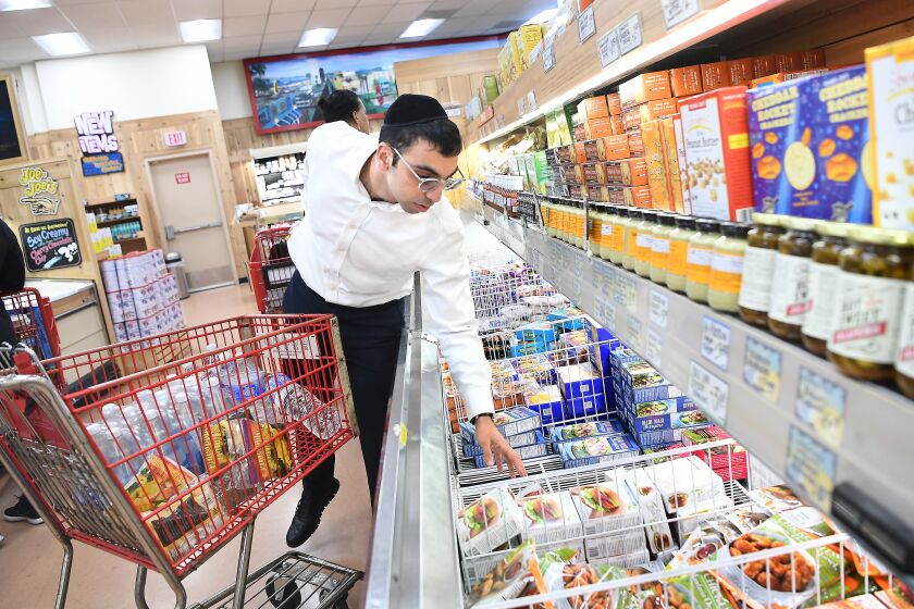 LOS ANGELES, CALIFORNIA MARCH 20, 2020-Eli Mojdehiazad, 26, shops for groceries to be delivered to senior citiens in Los Angeles as the caronavirus spreads. Mojdehiazad has volunteered several times for a Jewish WhatsApp group that delivers food to seniors. (Wally Skalij/Los Angeles Times)
