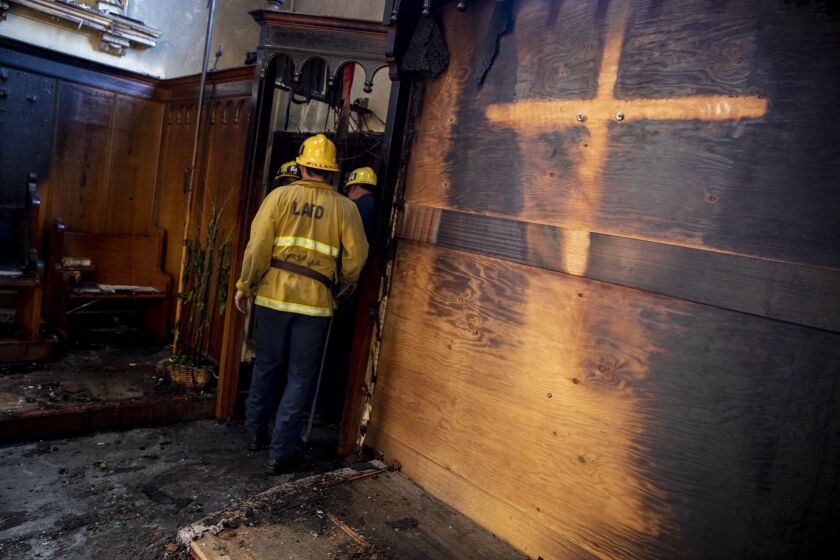 Los Angeles, CA - February 06: A cross removed by firefighters left an imprint inside the church as Los Angeles City firefighters look over the aftermath of a fire at St. Johns United Methodist Church Sunday, Feb. 6, 2022 in Los Angeles, CA. (Brian van der Brug / Los Angeles Times)