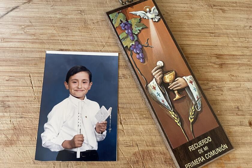 A photo of the author's First Communion, along with a souvenir from the ceremony
