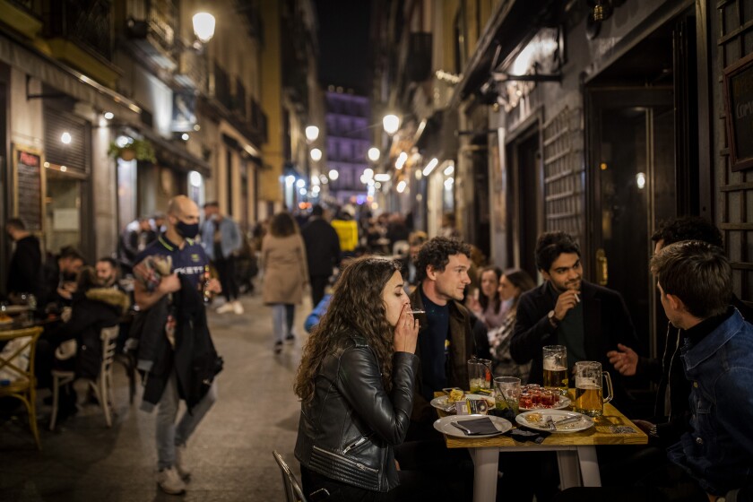 Tourists and locals have drinks at a bar in downtown Madrid, Spain