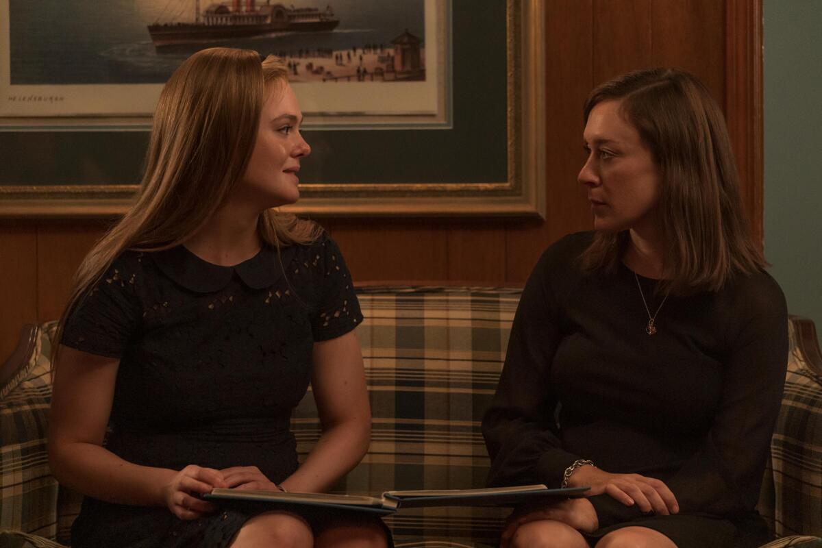 A daughter and her late boyfriend's mother sitting on a plaid couch in mourning clothes.