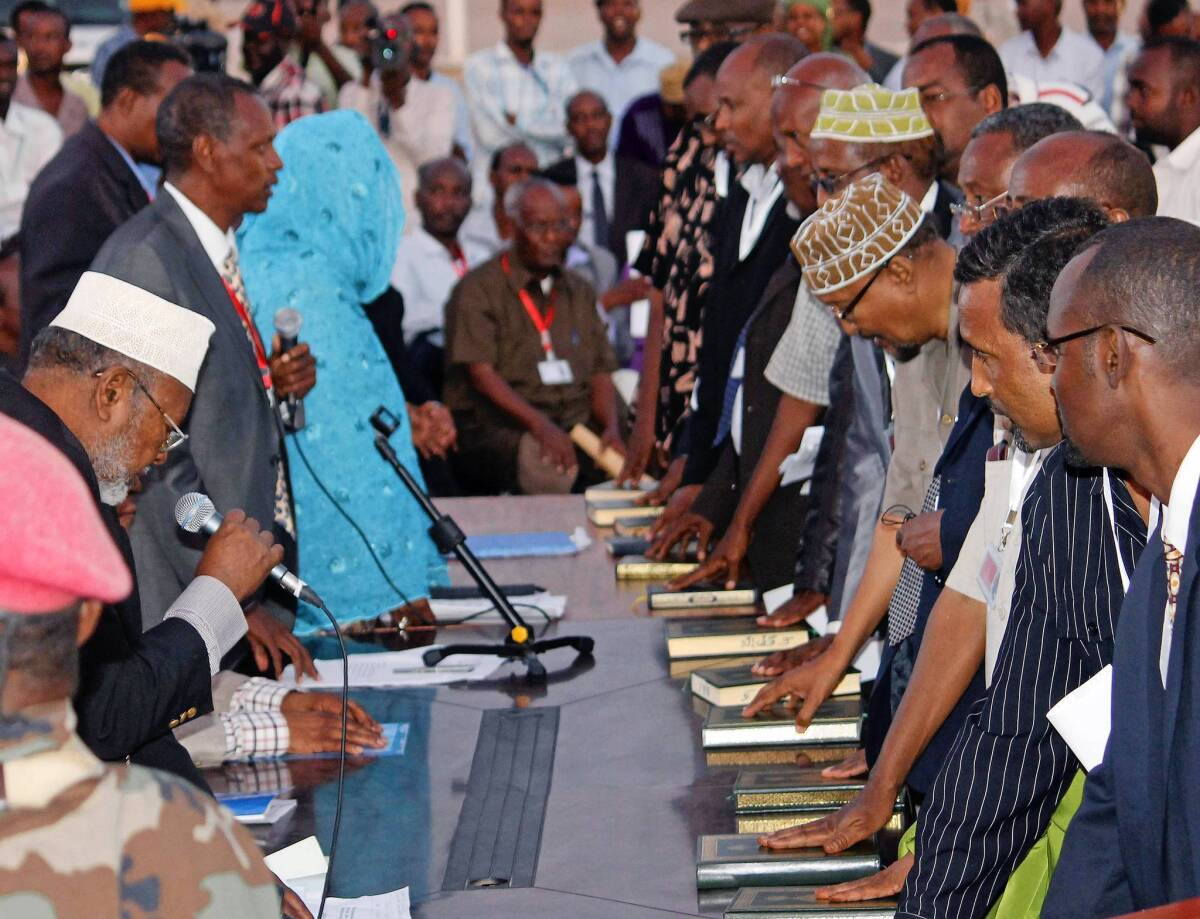 Members of Somalia's new parliament place their hands on copies of the Koran as they take the oath of office in Mogadishu, the capital.