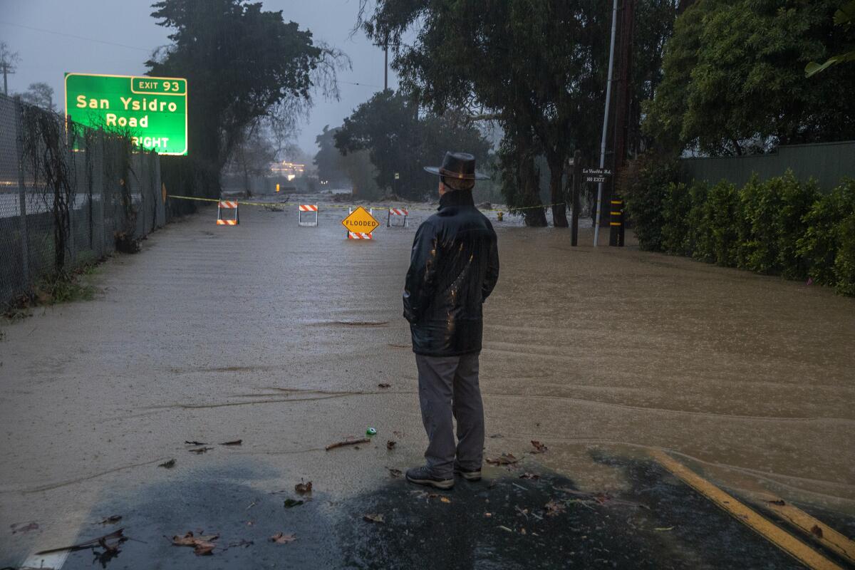 A man at the edge of a flooded street.