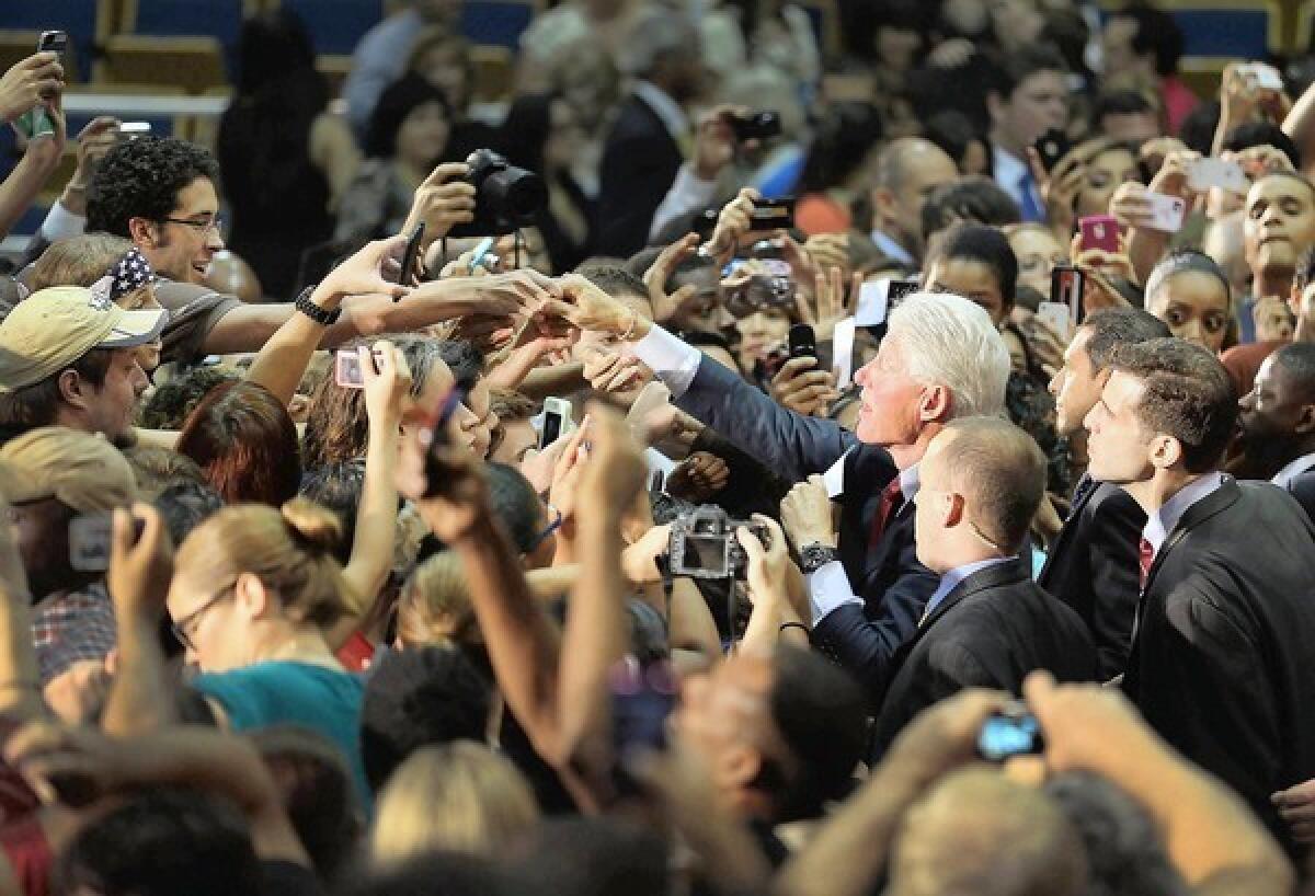 Former President Clinton greets the crowd after a campaign speech on behalf of President Obama at Florida International University in Miami.