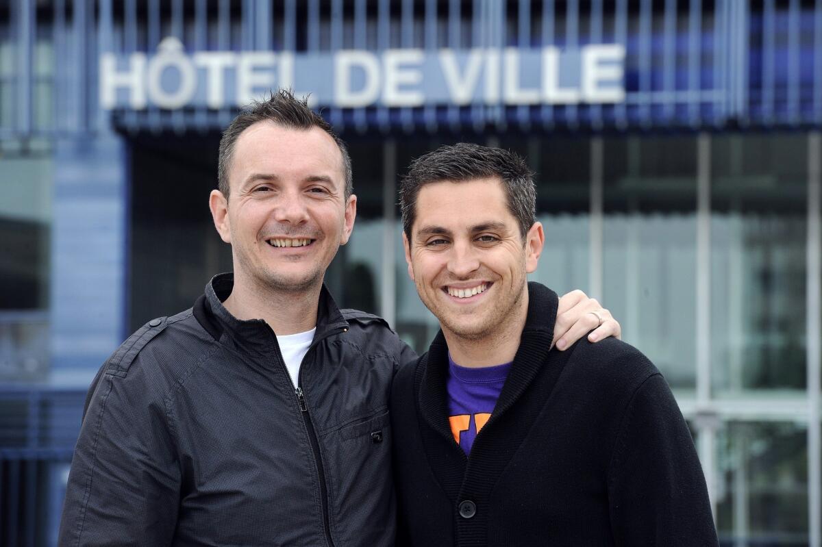 Vincent Autin, left, and his partner, Bruno Boileau, stand in front of the city hall of Montpellier, France. They are set to become the first gay couple in the country to wed under a new law allowing legalizing same-sex marriage.