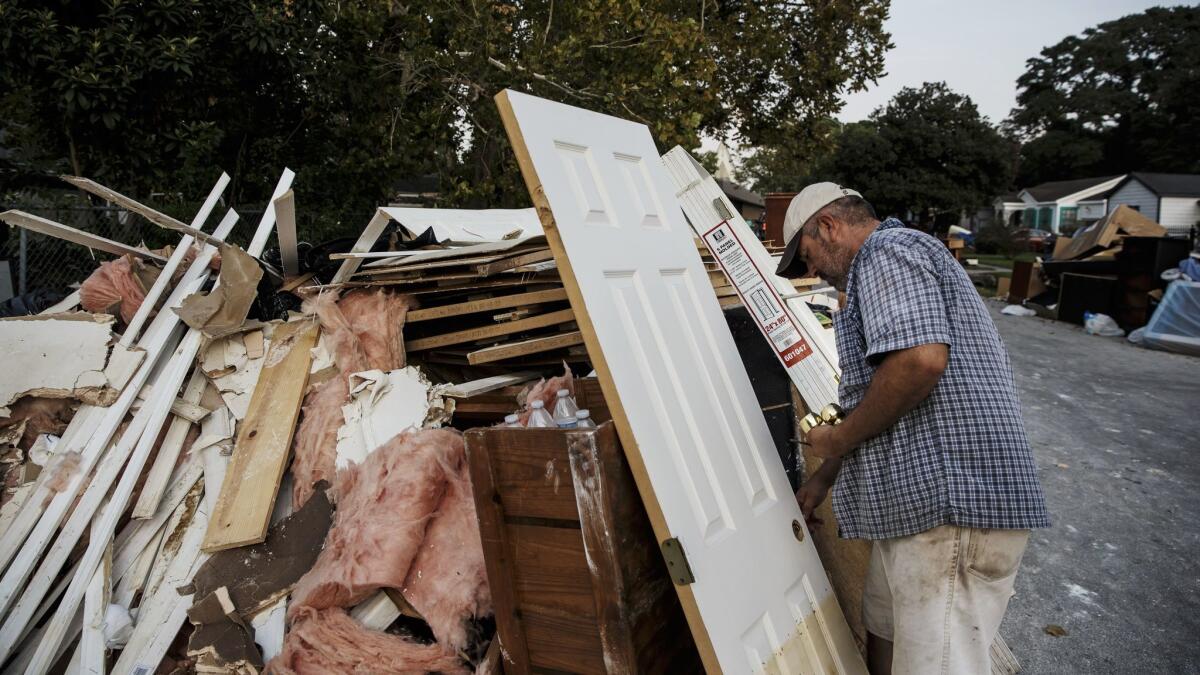Lino Saldana salvages doorknobs to save money to rebuild his flooded home in the Kashmere Gardens neighborhood of Houston.