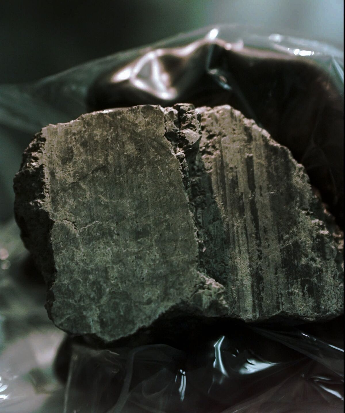 FILE - The meteorite labeled ALH84001 is held in the hand of a scientist at a Johnson Space Center lab in Houston, Aug. 7, 1996. Scientists say they've confirmed the meteorite from Mars contains no evidence of ancient Martian life. The rock caused a splash 25 years ago when a NASA-led team announced that its organic compounds may have been left by living creatures, however primitive. Researchers chipped away at that theory over the decades. A team of scientists led by Andrew Steele of the Carnegie Institution published their findings Thursday, Jan. 13, 2022. (AP Photo/David J. Phillip)