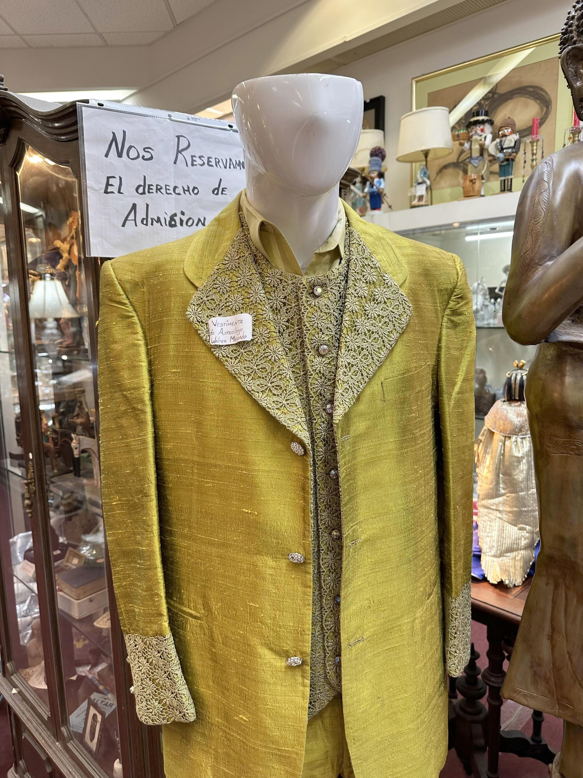 A mannequin in a yellow shirt, vest and jacket.
