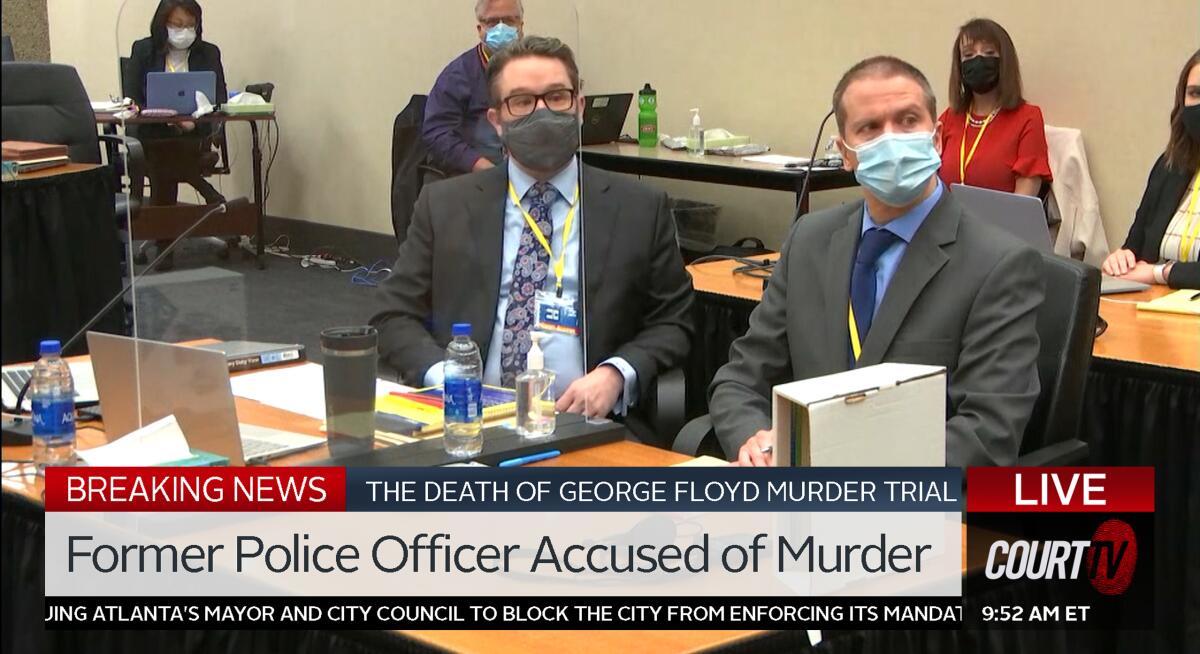 Attorney Eric Nelson and Minneapolis police officer Derek Chauvin sit at a desk, as seen on Court TV.