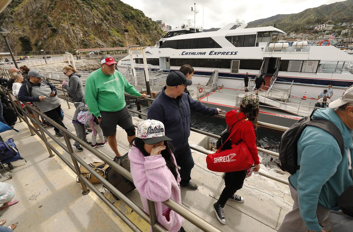 Passengers wait in line to board a Catalina Express ferry