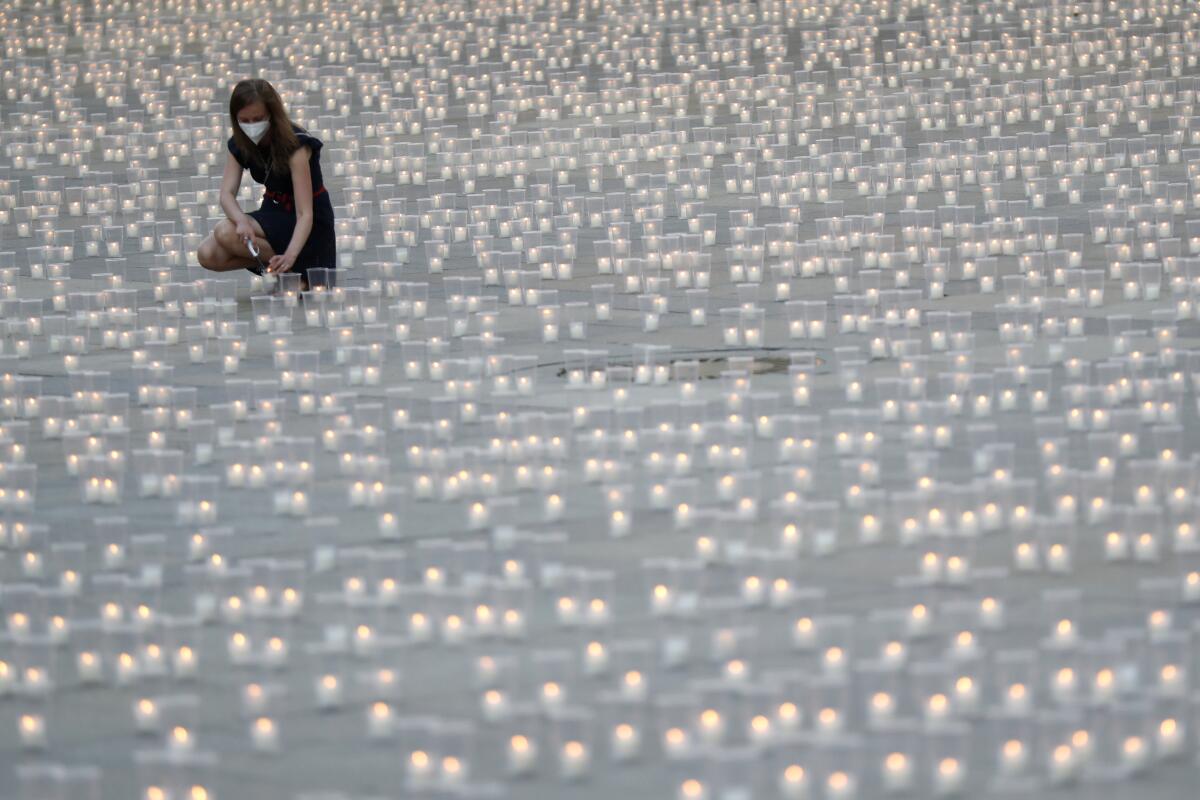 Ground covered in lighted candles in memory of COVID-19 victims