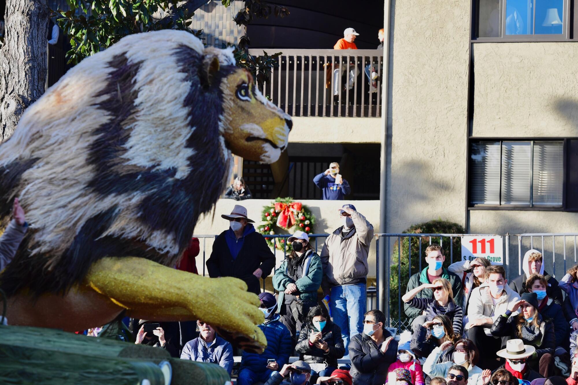People on the sideline get a close-up view of a lion decoration on a float