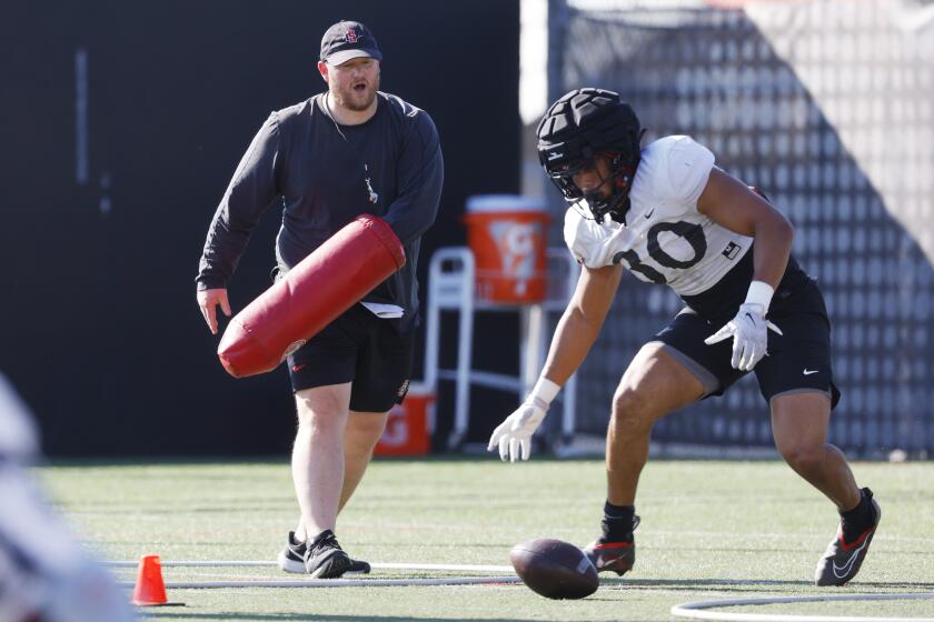 San Diego CA - March 21: San Diego State defensive coordinator Eric Schmidt works a drill with Dominic Oliver at practice on Thursday, March 21, 2024. (K.C. Alfred / The San Diego Union-Tribune)