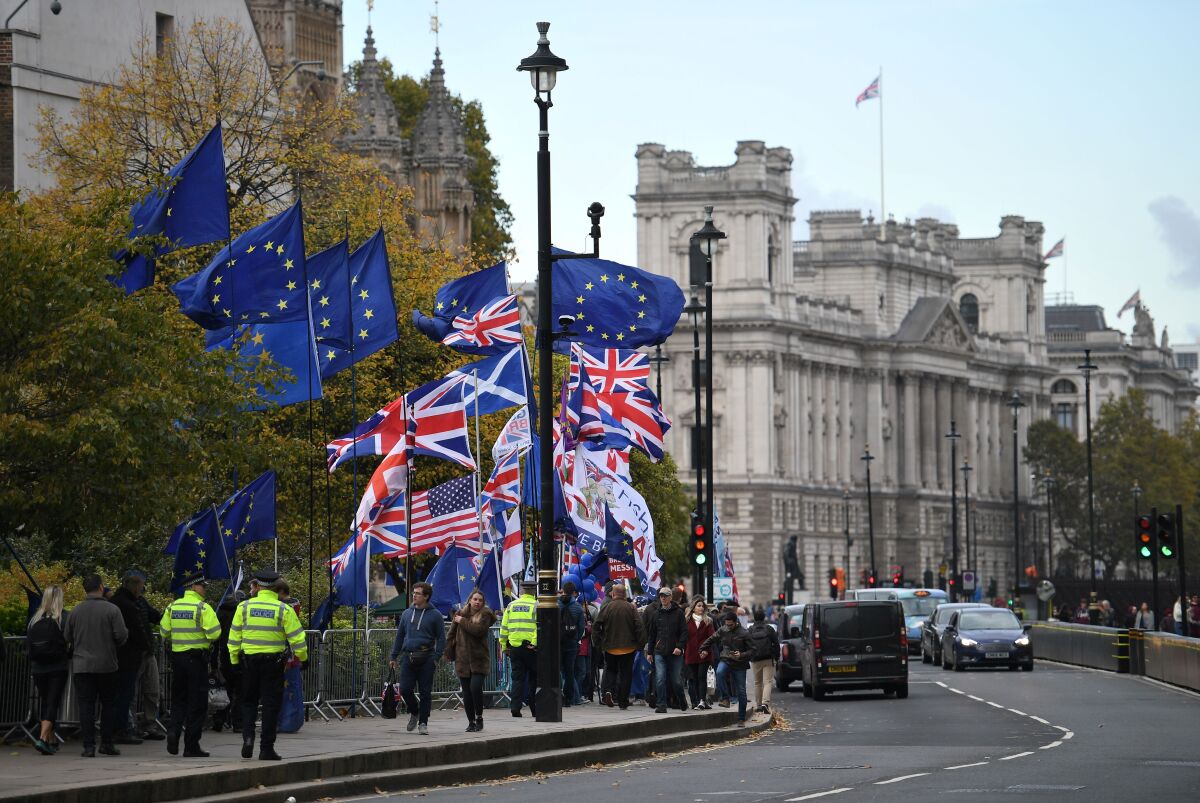 Protesters carry European Union and Union Jack flags on the sidewalk near the Houses of Parliament in central London on Oct. 29, 2019.