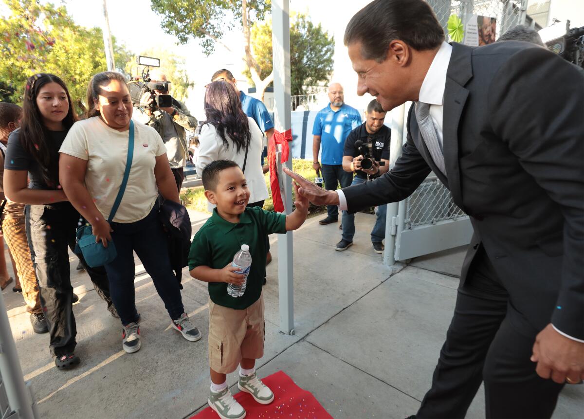 LAUSD Supt. Alberto M. Carvalho shakes hands with a young boy arriving at school 