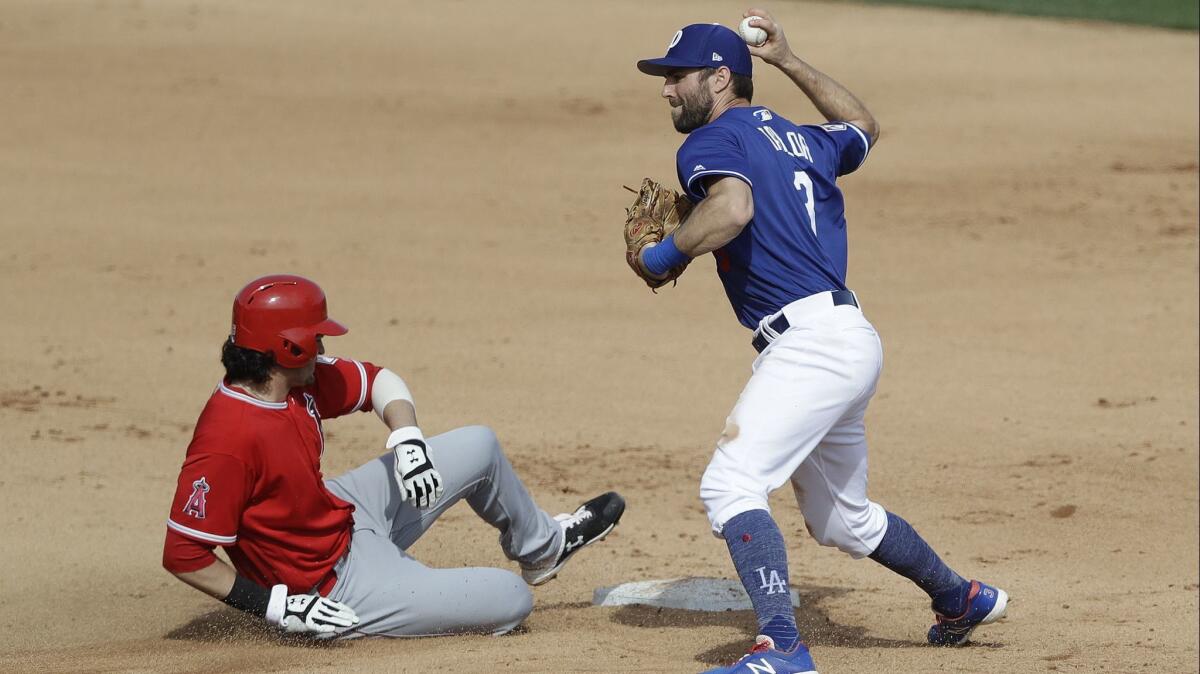 Angels' Jarrett Parker, left, is forced out at second base as Dodgers' Chris Taylor attempts to throw to first base during the fourth inning of a spring training game.