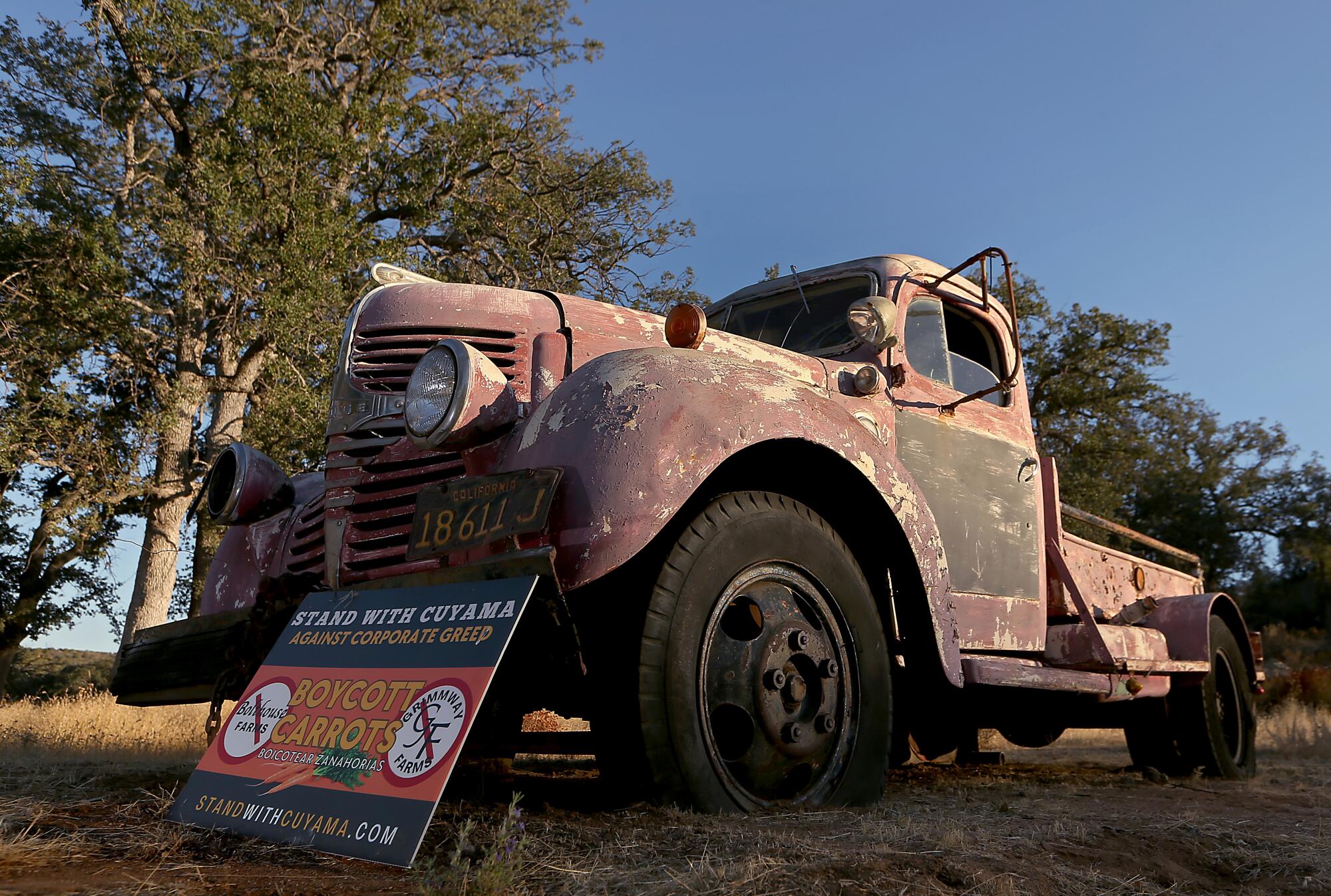 An old truck props up a sign promoting a boycott against two companies that farm carrots in the Cuyama Valley.