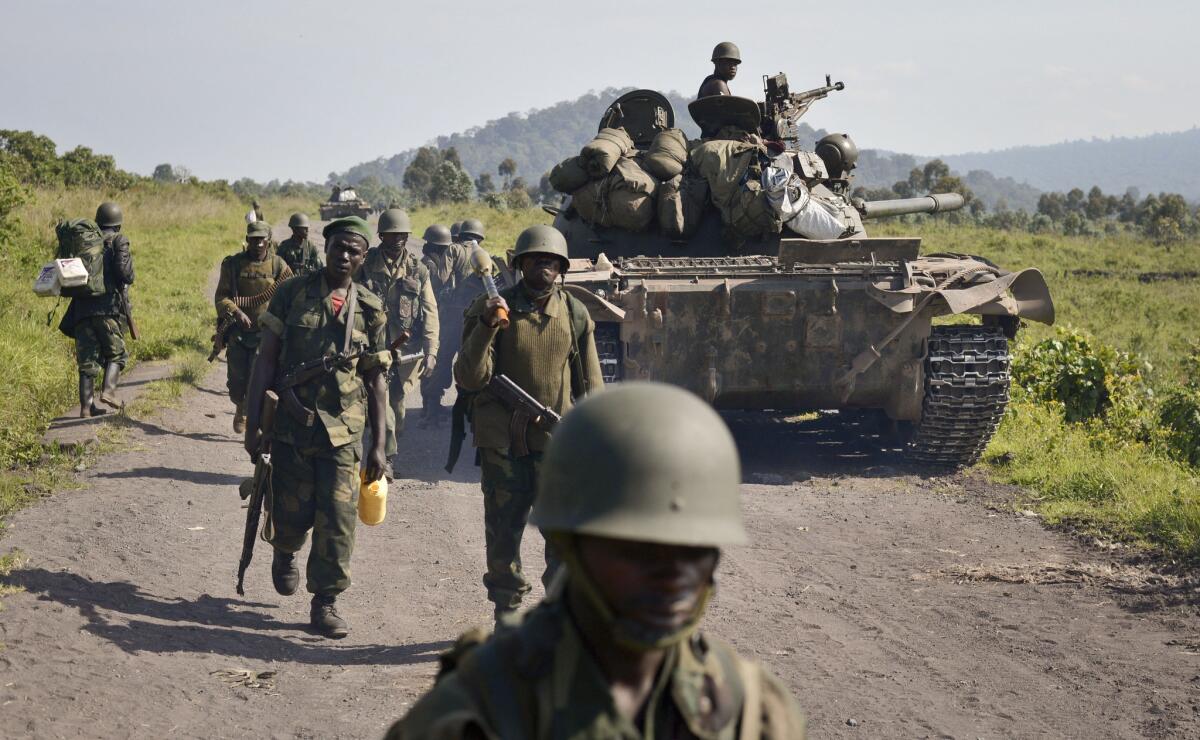 Last month, Congolese army soldiers march past a tank aimed toward Kibumba Hill, which was occupied by M23 rebels, near the provincial capital of Goma in the eastern Democratic Republic of Congo.