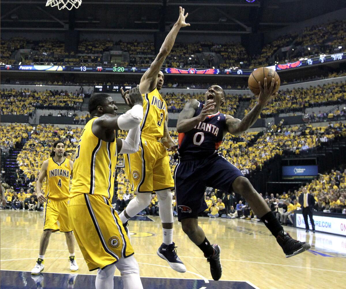 Hawks point guard Jeff Teague drives down the lane against Pacers center Roy Hibbert and point guard George Hill (3) in the first half Saturday.