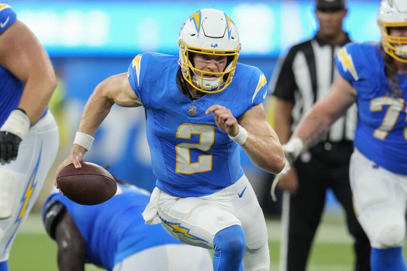 Los Angeles Chargers quarterback Easton Stick (2) carries for a gain in the second half.