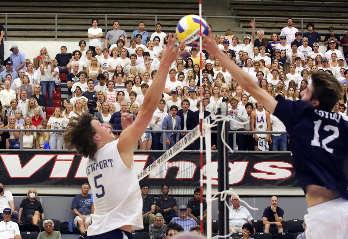 Newport Harbor's Riggs Guy (5) and Loyola's Sean Kelly (12) joust for the ball during the Division 1 boys' volleyball final.