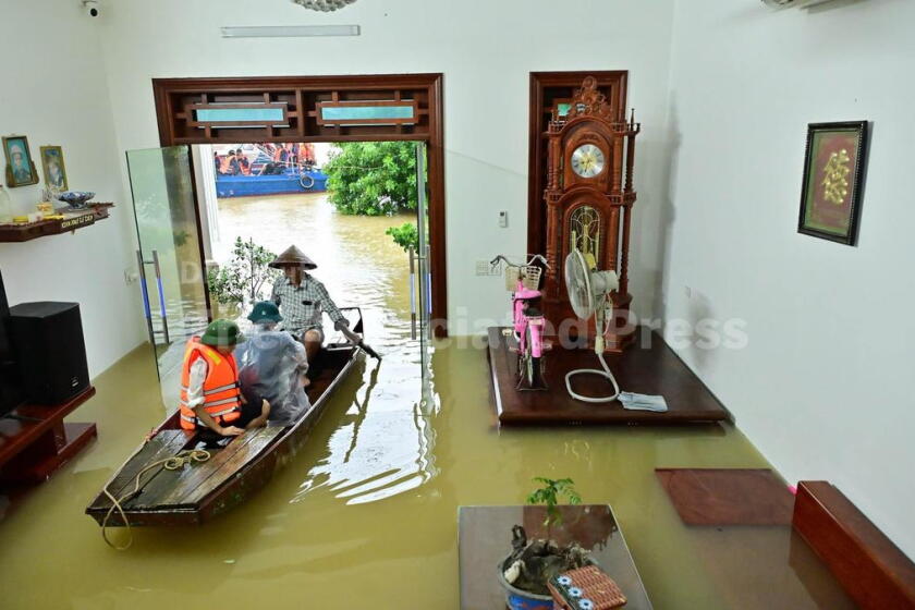 Local residents commute by boat on flooded village road after several days of rain in Ninh Binh province, Vietnam, Friday, Sept. 18, 2026. (Thuy Dung/VNA via AP)