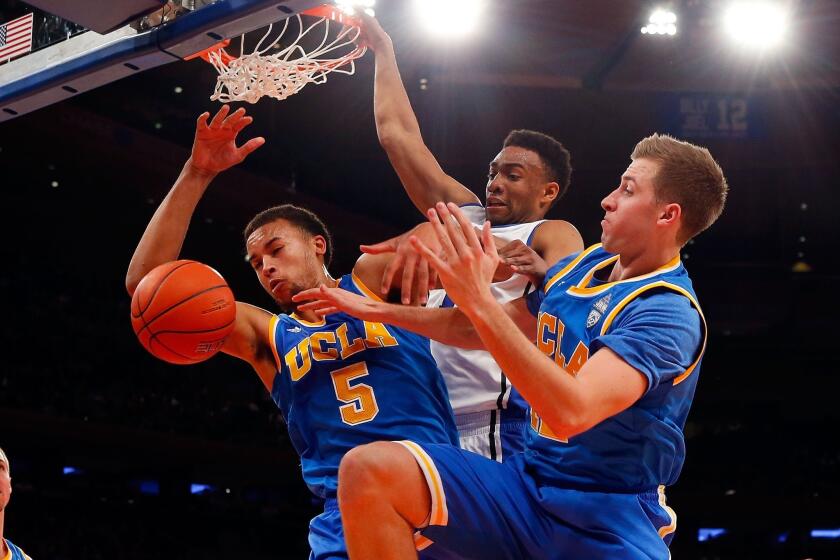 UCLA's Kyle Anderson, left, and David Wear, right, battle Duke's Jabari Parker for a rebound during the Bruins' 80-63 loss at Madison Square Garden in New York on Thursday.