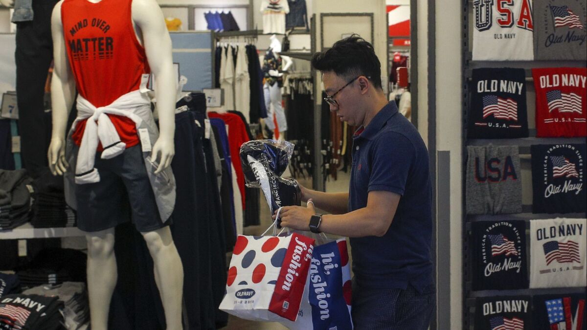 A man buys clothes at a mall in Beijing on Monday.