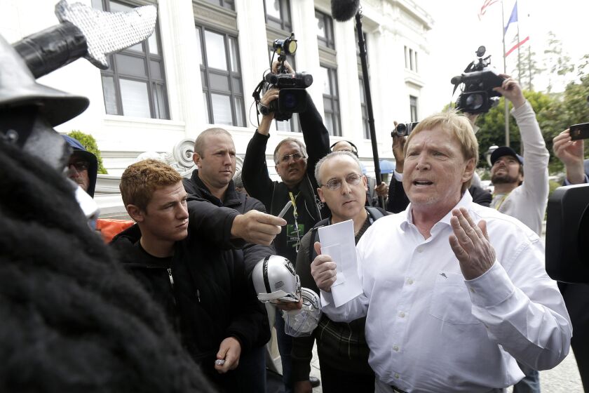 Raiders owner Mark Davis, right, speaks to fans and media outside the NFL's owners meetings in San Francisco.