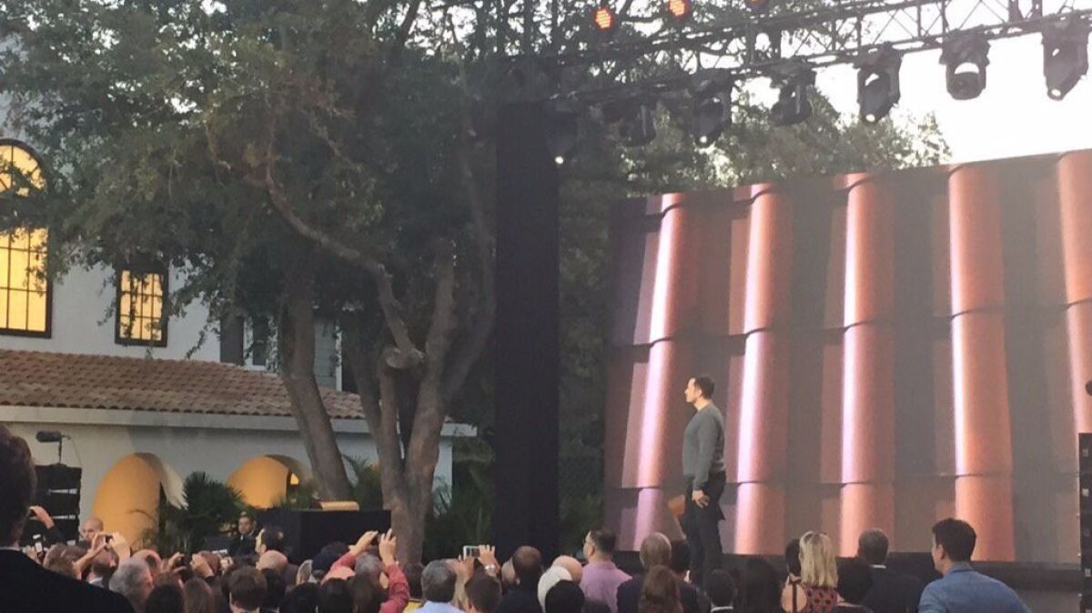At Universal Studios Hollywood's old "Desperate Housewives" set, Tesla CEO Elon Musk shows off a new solar tile roof to be produced by SolarCity, which Tesla is buying. Four Wisteria Lane homes on the set were re-roofed with the tiles.