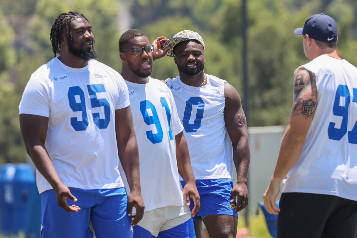 Rams defenders (from left) Bobby Brown III, Kobie Turner, Byron Young, and Michael Hoecht talk on the practice field