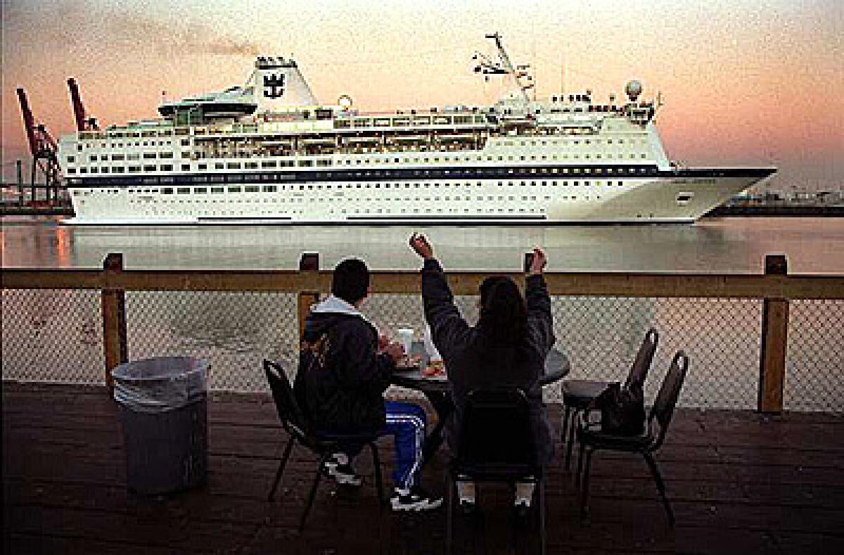 A couple looks on as a cruise ship departs the Port of Los Angeles in San Pedro.