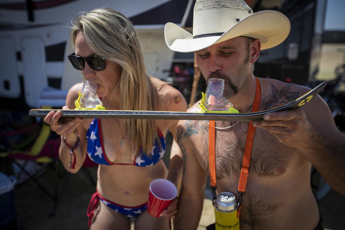 Lindsay Dal Porto, left, and Spencer Pierce do shots on a ski at their RV in the RV Resort area.