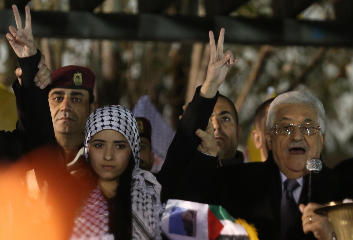 Palestinian Authority President Mahmoud Abbas, right, delivers a speech during a ceremony to celebrate the 50th anniversary of his Fatah movement in Ramallah on Dec. 31. The Palestinian Authority submitted papers Jan. 2 to the United Nations to join the International Criminal Court.
