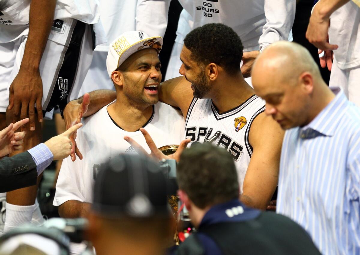 Tony Parker, left and Tim Duncan, right, celebrate after winning the NBA championship with a 104-87 win in Game 5 over the Miami Heat.