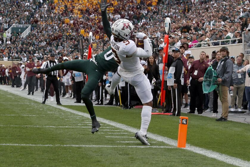 Minnesota's Daniel Jackson, right, catches a pass for a touchdown against Michigan State's Charles Brantley during the first quarter of an NCAA college football game, Saturday, Sept. 24, 2022, in East Lansing, Mich. (AP Photo/Al Goldis)