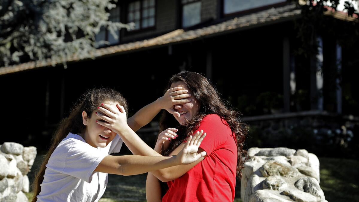 Abby Olague, 15, left, and her sister Bella Olague, 14, of Chino improvise their "Bird Box" pose at the Monrovia house used in filming the movie.