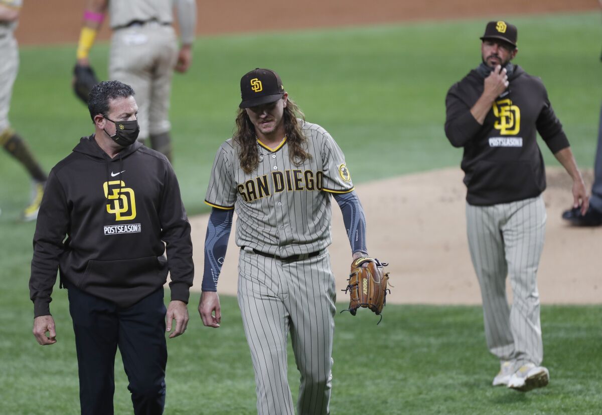 Mike Clevinger of the San Diego Padres is pulled from the game by manager Jayce Tingler (right) in the second inning Tuesday.