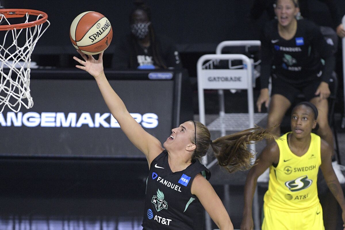 New York Liberty forward Sabrina Ionescu goes up for a shot as Seattle Storm guard Jewell Loyd, right, watches during the second half of a WNBA basketball game, Saturday, July 25, 2020, in Ellenton, Fla. (AP Photo/Phelan M. Ebenhack)