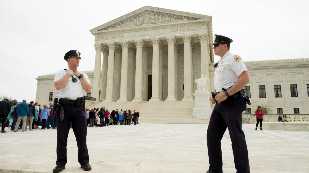 Police stand outside the Supreme Court, where justices on Tuesday denied terrorism victims' claims against Arab Bank, a Jordanian institution with offices in New York City that had been accused of facilitating the transfer of fund to terrorists.