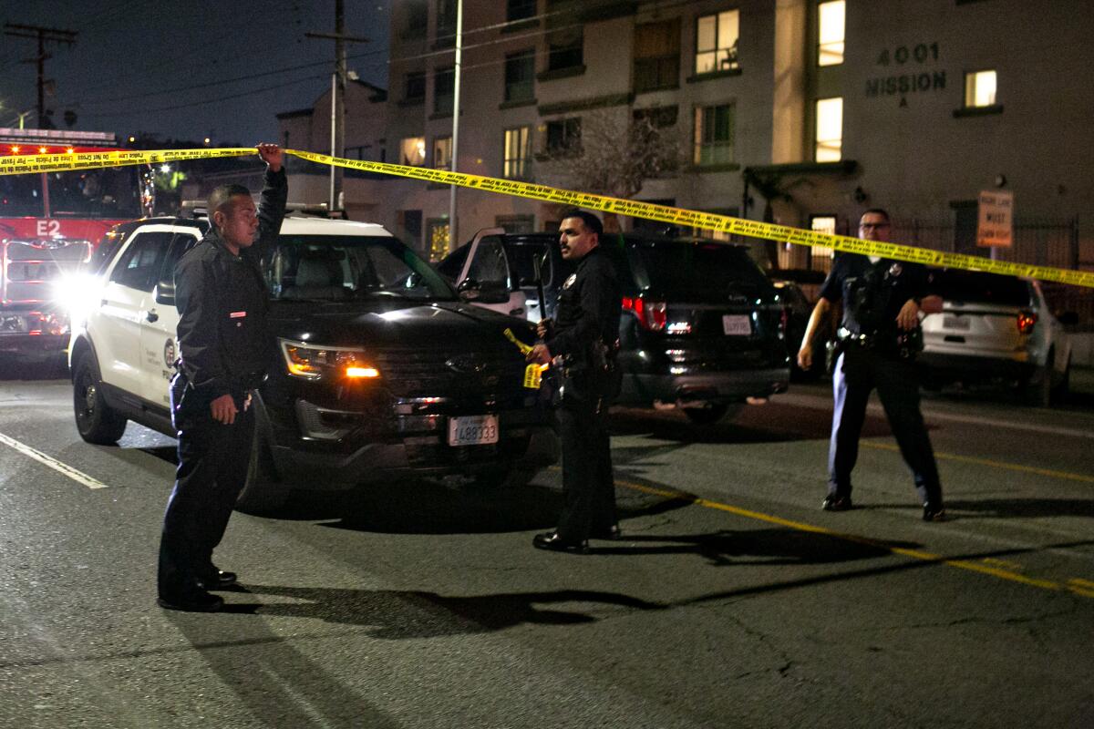 L.A. police officers stand near where three officers were shot.