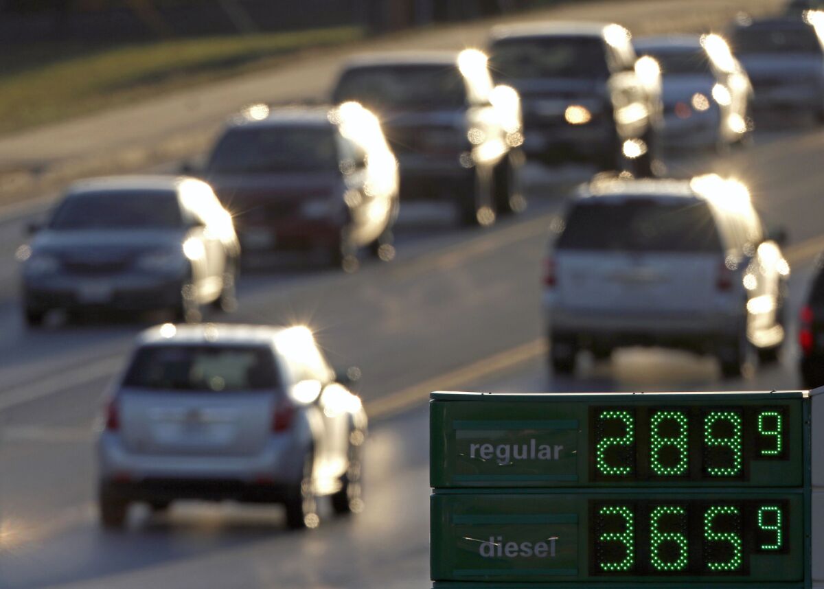 Motorists drive past a gas station selling regular unleaded gasoline for less than $3 a gallon on Nov. 26 in Missouri. The EPA released a report Thursday showing the average fuel economy for new vehicles in 2012 was the highest it has ever been.