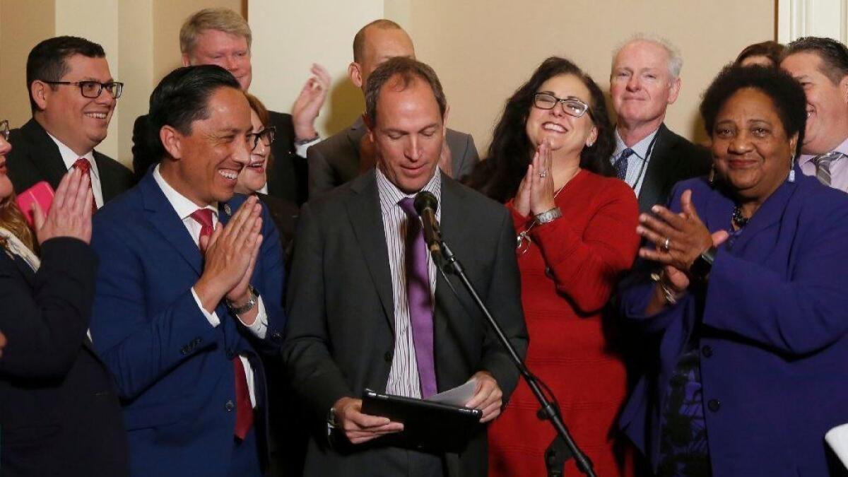 Assemblyman Brian Maienschein, center, receives applause from Democratic Assembly members after announcing he was switching party registration from Republican to Democrat.