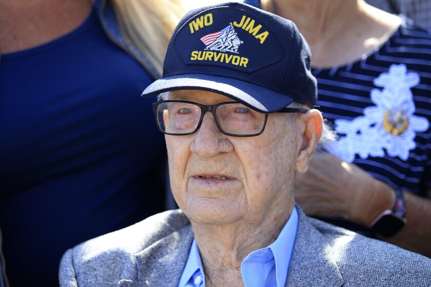 A man in a hat with a patch that says Iwo Jima Survivor